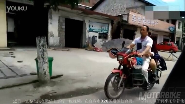 Hombre ciego llevando una moto 01